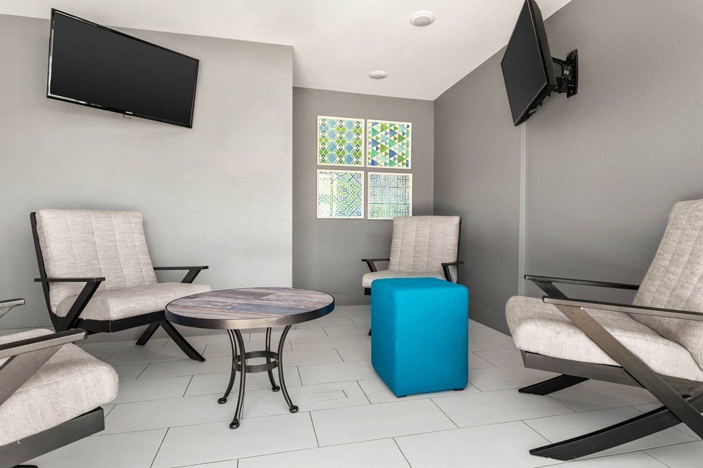 a living room with a table and chairs and a television a living room with a table and chairs and a television at South Lamar Village, Austin, TX, 78704